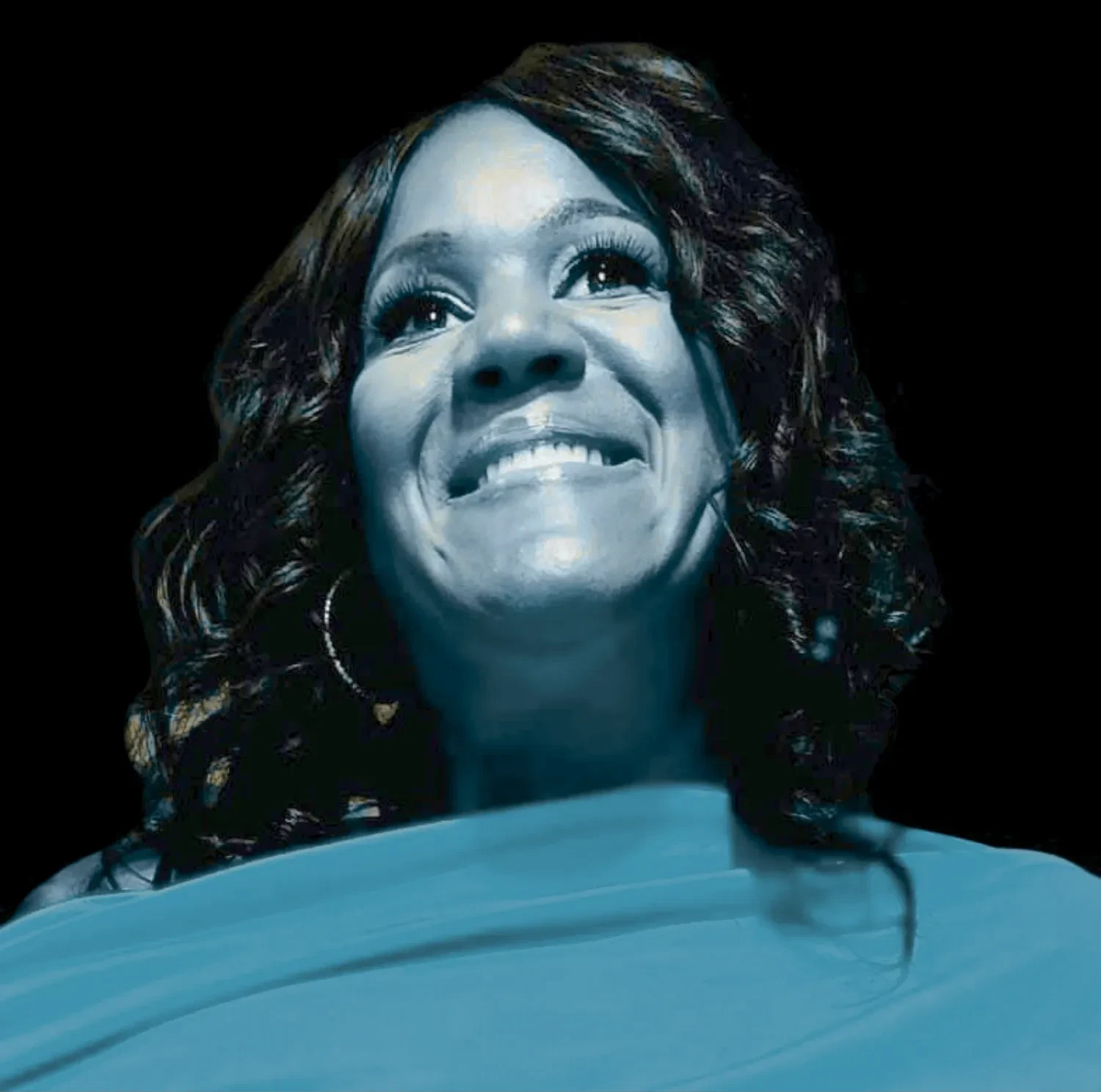 Dr. Keisha Scarlett looking upward in cyan-toned light